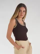 Musculosa marrón oscura, al cuerpo, sin mangas, con ribetes en contraste de color beige y negro en el escote y las sisas.