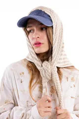 Chal pañuelo de formato triangular tejido a mano en lana merino y seda, con diseño de rayas horizontales en tonos beige y blanco.