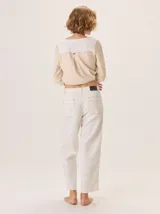 Pantalón de pana color gris oscuro, de corte barrel (holgado en caderas y muslos, ligeramente afín hacia el tobillo). Presenta costuras visibles en contraste de color amarillo claro, especialmente en la zona de la rodilla y el ruedo.