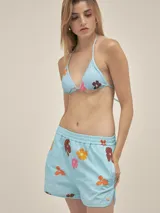 Short de tejido seersucker de algodón, color blanco con rayas verticales oscuras. Presenta cintura elastizada y bolsillos laterales.