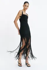 Vestido largo entallado negro con escote cuadrado, tirantes anchos y bajo acabado en flecos largos a tono.