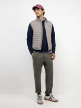 Chaleco acolchado de hombre con cierre frontal de cremallera, cuello alto y bolsillos laterales. Presenta un diseño de costuras horizontales y logo engomado en el pecho.