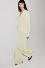 Pantalón de corte recto y tiro medio, confeccionado en tejido fluido de lyocell. Presenta cintura elástica con cordón ajustable.