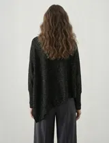 Poncho verde de tejido lurex, con cuello recto, manga japonesa con puños y terminación asimétrica.