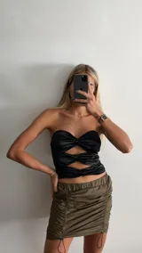 Minifalda color verde militar, con cintura elástica y cordones ajustables en los laterales.