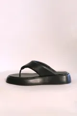 Sandalias negras de cuero sintético con plataforma y diseño de tanga.
