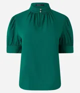 Blusa verde esmeralda de crepé con cuello alto con botones dobles y pequeña abertura abajo y mangas cortas abullonadas con botones.
