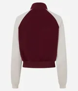 Saco femenino de poliviscosa, color blanco con mangas raglán marrones y ribetes blancos. Tiene cuello alto, cierre frontal de cremallera y bordado lettering "Kansas City" en el pecho.