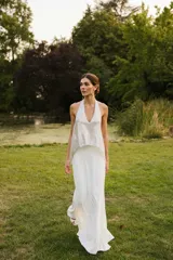 Vestido largo de novia color blanco, con cuerpo superior estilo halter de lentejuelas brillantes y falda larga fluida y ajustada.