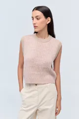 Chaleco de punto color rosa con detalles en beige, cuello redondo y sin mangas.
