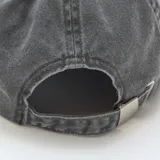 Gorra tipo baseball de algodón con efecto lavado, color negro, con bordado frontal en color blanco que incluye texto decorativo.