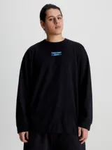 Remera de manga larga Calvin Klein Jeans, color negro, con corte oversized y cuello redondo. Presenta un logo estampado en el centro del pecho sobre una franja horizontal azul.