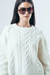 Sweater de punto color bordó con diseño de trenzas y relieves. Presenta cuello redondo, mangas largas y terminaciones acanaladas en puños y ruedo.