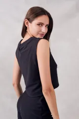 Top negro de algodón y poliéster, corte crop y cuello redondo.