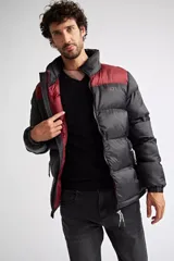 Campera puffer de nylon para hombre, con diseño bicolor en azul marino y mostaza en la parte superior. Cuenta con cierre frontal completo, mangas largas con puños elásticos y bolsillos laterales con cierre. Incluye logo estampado en el pecho.