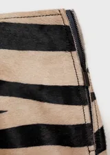 Falda corta de tiro medio con estampado animal print de cebra. Presenta un diseño recto y cierre de cremallera lateral.