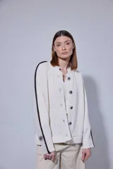 Saco de punto acanalado en color gris claro, con cierre frontal de botones oscuros. Presenta un diseño de bloques de color en las mangas, combinando negro y marrón, y un cuello redondo.