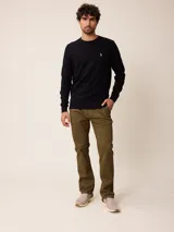 Sweater de punto con cuello redondo, manga larga y puños acanalados. Presenta un pequeño logo bordado en el pecho.