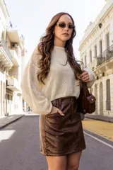 Buzo color crudo de tejido calado con transparencia, de corte holgado y mangas largas.