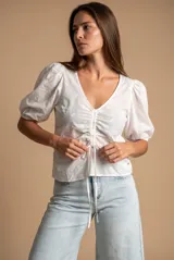 Blusa marrón de algodón con bordados sutiles, escote en V, mangas cortas abullonadas y detalle de fruncido con cordón ajustable en el centro del frente.