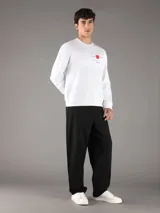 Buzo Calvin Klein blanco de manga larga, confeccionado en algodón regenerado y poliéster reprocesado con interior de felpa suave. Presenta cuello redondo, puños y dobladillo acanalados, y un estampado frontal con texto y un cuadrado rojo.