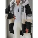 Campera peluda de mujer marca United Uy, con capucha y cierre frontal de cremallera. Presenta diseño de rayas horizontales en bloques de colores blanco, gris, beige y negro, con textura de piel sintética y puños elásticos.