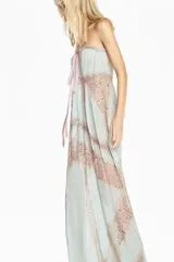 Vestido largo de corte fluido confeccionado en chiffon color verde agua, con diseño strapless y detalle de lazo frontal. Presenta paneles verticales de encaje en tono beige que recorren la prenda, aportando textura y un estilo romántico.