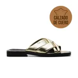 Sandalia casual de cuero color dorado, con tiras cruzadas en el empeine y suela plana.