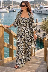 Conjunto de tres piezas estampado con patrón geométrico y floral en tonos beige, negro y blanco, compuesto por un top strapless con fruncido elástico, un pantalón ancho de tiro alto y un kimono largo de mangas amplias.