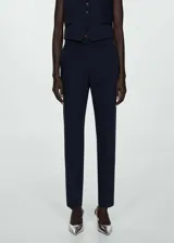 Pantalon de vestir de corte recto y tiro medio, con bolsillos laterales y bolsillos de ribete en la parte posterior. Presenta trabillas para cinturón y cierre frontal.