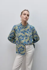 Camisa de calce amplio y fluido de viscosa liviana, con estampado de rayas verticales irregulares en blanco y negro, cuello mao, abotonadura frontal y mangas largas.
