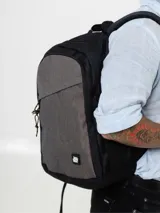 Mochila grande negra y gris con bolsillo lateral de red, correas laterales de compresión, correas ajustables acolchadas y bolsillo frontal diagonal.