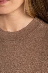Sweater de tejido de punto fino en color arena, con cuello redondo y mangas cortas. Presenta un diseño minimalista con un pequeño detalle metálico en el ruedo.