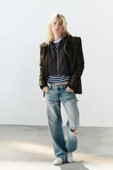 Jeans de tiro bajo y corte recto, color celeste con efecto lavado. Presenta diseño de doble tiro con detalle de short superpuesto con roturas, además de roturas adicionales en las perneras. Cuenta con cinco bolsillos, trabillas para cinturón y cierre frontal con cremallera y botón metálico.