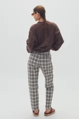 Pantalón de vestir de corte recto con estampado de cuadros escoceses en tonos grises, blancos y marrones.