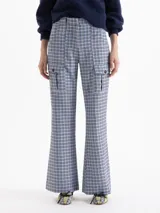Pantalón de tiro alto con diseño de corte recto y ligeramente acampanado, confeccionado en tela con estampado de cuadros en tonos celestes, marrones y negros. Presenta bolsillos tipo cargo en la parte frontal con solapas y botones, y bolsillos traseros.