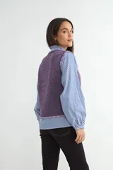 Chaleco de punto en color violeta, con cuello redondo y bordes deshilachados. Presenta una textura suave y un corte recto.