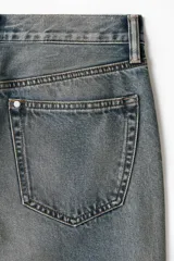 Pantalón jean de cinco bolsillos en denim de algodón rígido, con pierna recta apenas holgada y corte estándar. Cuenta con cintura clásica y cierre de botones.