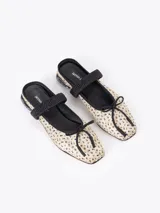 Ballerina tipo mule confeccionada en seda con estampado floral, ribetes en cuero negro, elástico en el empeine, lazo decorativo en la punta y taco bajo con incrustaciones de strass.