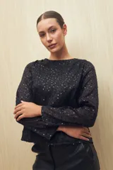 Blusa negra de manga larga con cuello redondo y lentejuelas a tono.