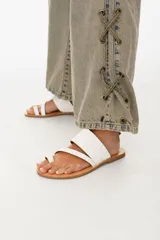 Sandalias de cuero color marrón con tira ancha sobre el empeine y tira entre los dedos.