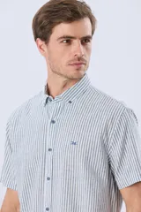 Camisa de manga corta confeccionada en mezcla de lino y algodón, con diseño de rayas verticales en tonos celeste y blanco. Cuenta con cuello camisero, botonadura frontal y bordado sutil en el pecho.