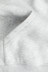 Buzo con capucha de doble capa, hombros caídos y bolsillo canguro frontal. Tejido de punto con interior cepillado suave y puños y bajo acanalados.