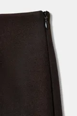 Falda pantalón de tiro alto confeccionada en tejido satinado, con detalle de puntilla en el ruedo. Cuenta con forro interior y cierre lateral con cremallera oculta.