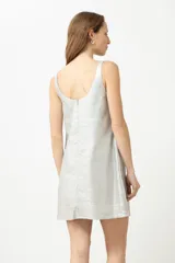Vestido corto plateado de lino con acabado metalizado, corte recto y cuello cuadrado.