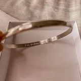Pulsera tipo esclava de media caña fabricada en plata 925, con superficie lisa y opción de grabado personalizado en su cara interna.