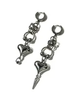 Aros colgantes de acero quirúrgico plateado con diseño asimétrico. Cuentan con argolla superior, sección de cadenas entrelazadas, dije de corazón abultado y un colgante adicional en punta.