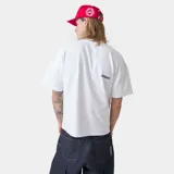 Camiseta blanca de corte "boxy fit" con estampado frontal que dice "emestudios" en azul con detalles rojos, y debajo "EXCLUSIVE PIECES SELECTED WITH CARE / MADRID".