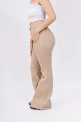 Pantalón tipo oxford de tiro alto, color beige, con diseño de cinco bolsillos y cierre frontal con botón y cremallera.