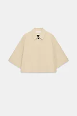 Chaqueta corta Zara ZW Collection de color beige, con cuello solapa, manga por debajo del codo, bolsillos laterales ocultos y cierre frontal con botones ocultos bajo solapa.